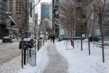Kanada, Montreal, 25 Aralık 2025: Karlı şehir caddesinde insanlar yürüyor, arabalar geçiyor.
