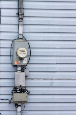 Kanada, Quebec, 27 Kasım 2025: Bağlı kablolarla birlikte mavi yan duvarda elektrik sayacı
