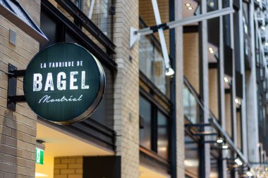 Kanada, Montreal, 24 Aralık 2025: Montreal Bagel Pastanesi tabelası modern bina koridorunda aydınlatıldı