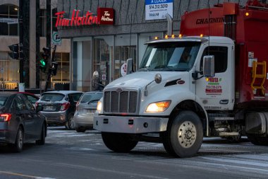 Kanada, Montreal, 22 Aralık 2025: Şehir kavşağında ünlü bir kahve dükkanının önünden geçen büyük bir kamyon