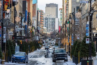 Kanada, Montreal, 22 Aralık 2025: Kentsel tatil süslemeleri ile hareketli kış şehri caddesi