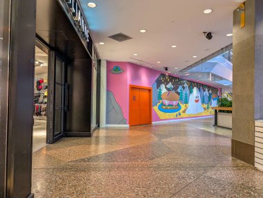 Kanada, Montreal, 22 Aralık 2025: Renkli duvar resmi, alışveriş merkezi içi, giyim mağazası, çizgi film sahnesi, yakınlardaki yürüyen merdiven