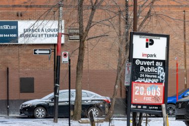 Kanada, Montreal, 22 Aralık 2025: Tuğla binalı karlı kentsel alanda park işaretleri.