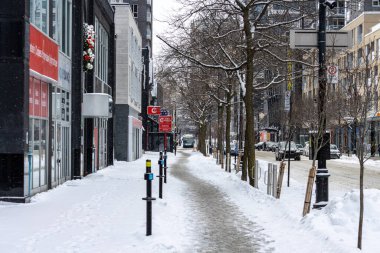 Kanada, Montreal, 25 Aralık 2025: Karlı şehir sokağı, çıplak ağaçlar, binalar, sakin kış günü.