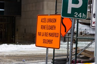 Kanada, Montreal, 24 Aralık 2025: Turuncu teslimat erişim levhası karlı sokak kentsel trafik işaretleri