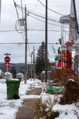 Kanada, Quebec, 29 Kasım 2025: Dur işareti, Noel Baba, çöp kutusu, kablolu karlı banliyö caddesi.
