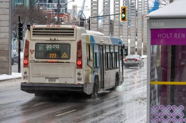 Kanada, Montreal, 24 Aralık 2025: Karlı şehir merkezinde toplu taşıma otobüsü sürüyor