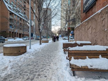 Kanada, Montreal, 25 Aralık 2025: Bankları, yürüyen insanları, yüksek binaları olan karlı şehir sokağı.