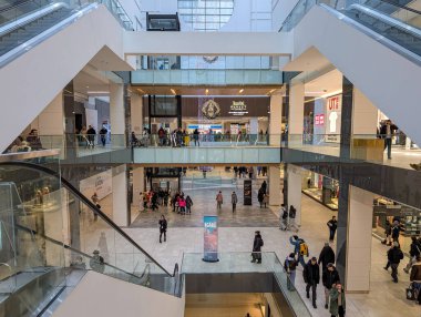 Kanada, Montreal, 23 Aralık 2025: Yürüyen merdivenler ve çok katlı mağazalar ile yoğun alışveriş merkezi.