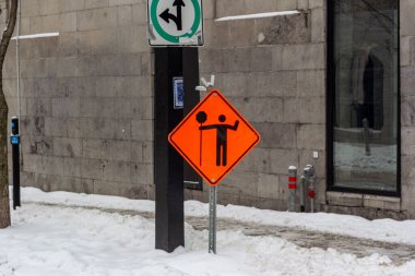 Kanada, Montreal, 25 Aralık 2025: Şehir inşaat tabelası, karlı kaldırım, yön okları, kış kenti manzarası.