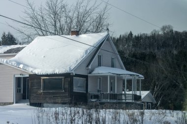 Kanada, Montreal, 26 Aralık 2025: Karla kaplı ev, kış manzarası, kırsal alan, ağaçlar, bulutlu gökyüzü