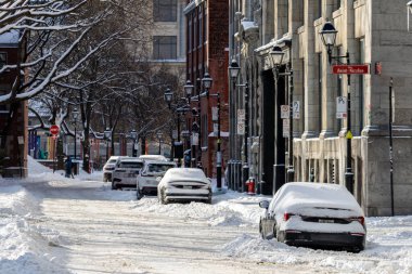 MONTREAL, CANADA, 24 Aralık 2025: Karlı şehir caddesi, park edilmiş arabalar, kış sahnesi, tarihi binalar, kentsel mimari, karla kaplı ağaçlar, gündüz atmosferi