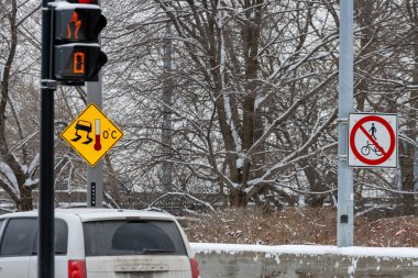 MONTREAL, CANADA, 25 Aralık 2025: Karlı trafik ışıkları ve buzlu yol uyarısı