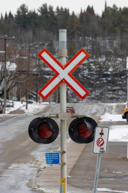 Kanada, Quebec, 27 Kasım 2025: Kışın demiryolu geçidi, uyarı ışıkları, ağaçlar, yayalara izin verilmiyor