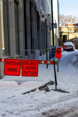 Kanada, Montreal, 24 Aralık 2025: Fransız tabelasıyla karlı kaldırım ablukası, kışın kent merkezi.