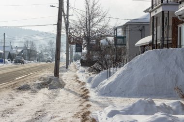 Kanada, 25 Ocak 2026: Bir yerleşim bölgesinde karlı bir cadde, elektrik hatları, kar yığınları, kış ağaçları