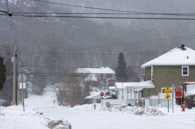 Kanada, Quebec, 30 Kasım 2025: Trafik ışıkları, elektrik hatları ve kış havası olan karlı bir yerleşim yeri.
