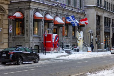 MONTREAL, CANADA, 24 Aralık 2025: Kış sokak sahnesi, şehir mimarisi, bayraklar, kar, park edilmiş araba, aşk heykeli, şehir oteli girişi, kentsel ortam