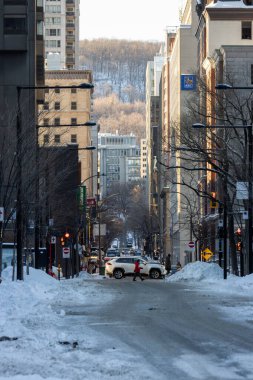 Kanada, Montreal, 24 Aralık 2025: Karlı şehir sokağı, yaya geçidi, kış sabahı, yüksek şehir binaları