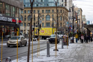 MONTREAL, Kanada, 22 Aralık 2025: Kar yayan ve trafiği olan kentsel kış şehri