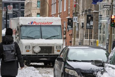 MONTREAL, CANADA, 24 Aralık 2025: Kış teslimat kamyonu sokak sahnesi, kentsel kar trafiği, şehrin kış caddeleri, karlı yollarda teslimat aracı, şehir merkezinde kar fırtınası, kentsel ulaşım kışları, şehir kar taşımacılığı