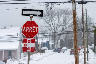 Kanada, Quebec, 30 Kasım 2025: Karlı cadde araçlarla dolu, Fransızca dur işareti, yukarıdan gelen yön oku