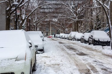 Kanada, Montreal, 25 Aralık 2025: Karla kaplı cadde park halindeki araçlarla bir yerleşim bölgesinde.