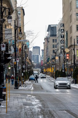 Kanada, Montreal, 23 Aralık 2025: Winter City sokak sahnesi, yayalar, arabalar, tatil ışıkları, binalar.