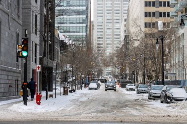 Kanada, Montreal, 25 Aralık 2025: Kar fırtınası sırasında şehir sokak sahnesi, trafik ışıkları parlıyor.