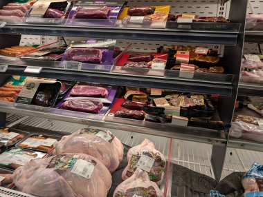 Kanada, Montreal, 22 Aralık 2025: Süpermarketin soğutmalı bölümünde paketlenmiş et çeşitliliği