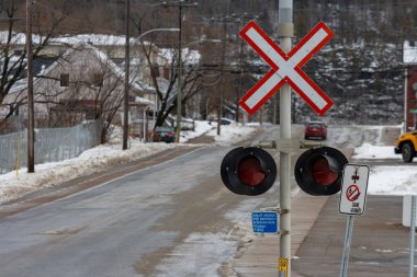 Kanada, Quebec, 27 Kasım 2025: Sakin sokak demiryolu kavşağında karlı bir kış günü ve ışıklar