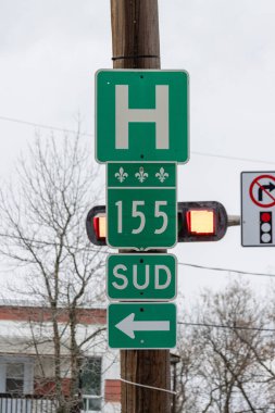 Kanada, Quebec, 27 Kasım 2025: Yeşil hastane yön tabelası kışın güneye giden caddeyi gösteriyor.