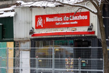 Kanada, Montreal, 25 Aralık 2025: Karla kaplı restoran kırmızı tabelalı ve inşaat eskrimiyle çevrili.