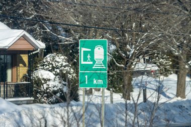 MONTREAL, CANADA, 26 Aralık 2025: Tren istasyonu tabelası, karlı manzara, kış, evler, ağaçlar