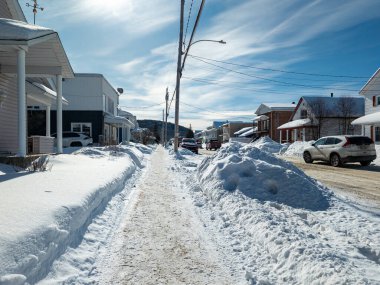 Kanada, 13 Şubat 2026: Mahalle sokağı, kış karı, mavi gökyüzü, elektrik hatları, park edilmiş arabalar