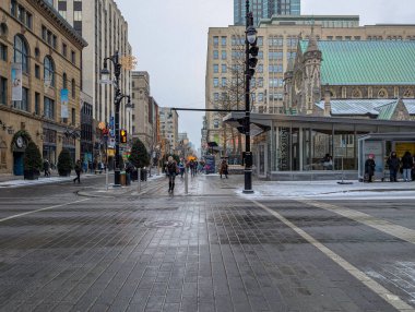 Kanada, Montreal, 22 Aralık 2025: Yayalar, eski mimari, kış günü ile karlı şehir caddesi.