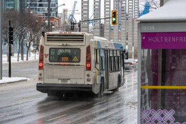 MONTREAL, CANADA, 24 Aralık 2025: Şehir otobüsü kış trafiği sokak sahnesinde
