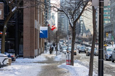 MONTREAL, CANADA, 24 Aralık 2025: Winter City sokak sahnesi, karla kaplı kaldırım, trafik, kentsel çevre, insanlar yürüyor, gündüz vakti, Kanada bayrağı, binalar, şehir manzarası