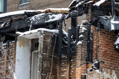MONTREAL, CANADA, 25 Aralık 2025: Yanmış bina kalıntıları, kar kaplı, hasarlı yapı, yanmış ahşap, tuğla duvar, kış manzarası
