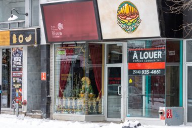 MONTREAL, CANADA, 25 Aralık 2025: Kışın mağazalar, karlı sokaklar, kiralık ticari alanlar, kentsel alanlar, küçük işletmeler, restoran tabelaları