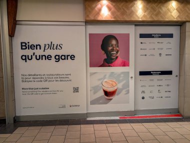 MONTREAL, CANADA, 24 Aralık 2025: Gülümseyen kadın ve kahve fincanı olan tren istasyonu reklam duvarı