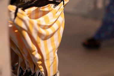 Rafta asılı sarı ve beyaz çizgili bir bikini.