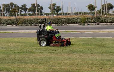Çim biçme makinesi kullanan bir adam. Bakım kavramı