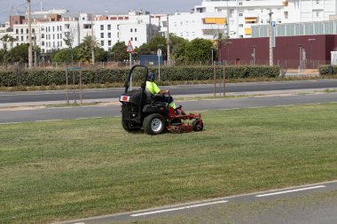 a man driving a lawn mower. Maintenance concept clipart