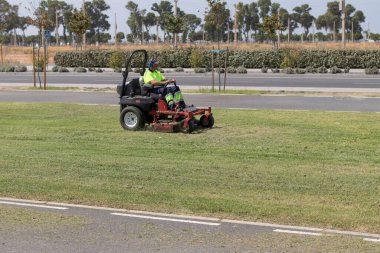 Çim biçme makinesi kullanan bir adam. Bakım kavramı