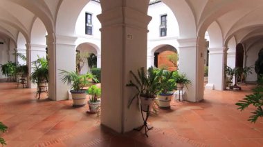 La Rabida Manastırı, Palos de la Frontera 'da beyaz kemerli, terasotta zeminli ve yeşil bitkilerle geleneksel İspanyol avlusu..
