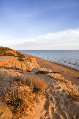 Endülüs, Doana 'daki turuncu tortulu kayalıkların ve el değmemiş kumlu sahil şeridinin çarpıcı hava manzarası. Altın saatinde dramatik kıyı manzarası.