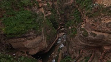 Yüksek açı, Ronda 'daki El Tajo Kanyonu' nun derinliklerini yakalıyor. Guadalevin Nehri 'nin kireçtaşı kayalıklar, antik tahkimatlar ve uçurumun kenarındaki tarihi beyaz evler arasında aktığını gösteriyor..