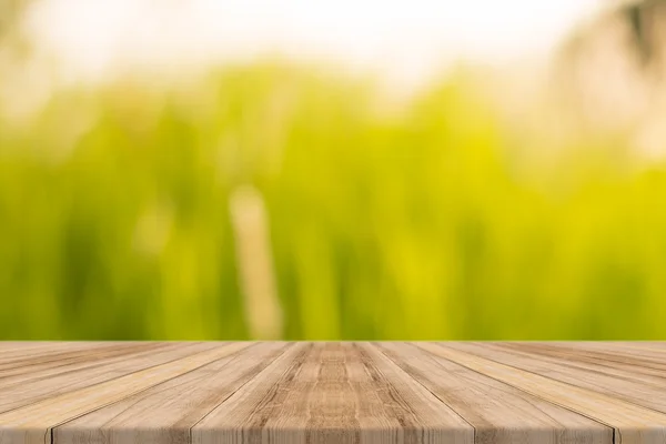 Tablero de madera mesa vacía en frente de fondo borroso. Perspectiva de madera marrón sobre los árboles borrosos en el bosque - se puede utilizar para mostrar o montar sus productos. temporada de primavera. vintage imagen filtrada . Imagen de archivo
