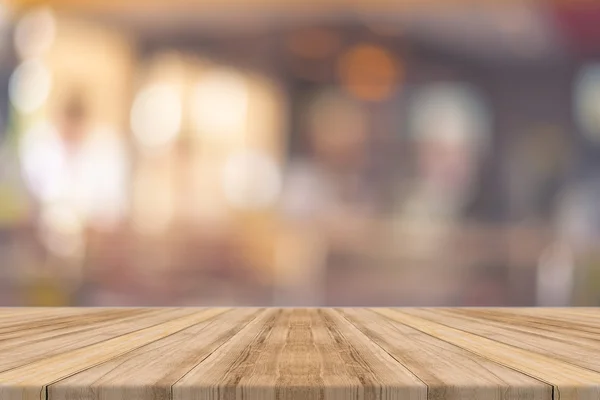 Tablero de madera mesa vacía en frente de fondo borroso. Perspectiva de madera marrón sobre desenfoque en el restaurante - se puede utilizar para la exhibición o montaje de sus productos.Prepárese para la exhibición del producto . Imágenes de stock libres de derechos